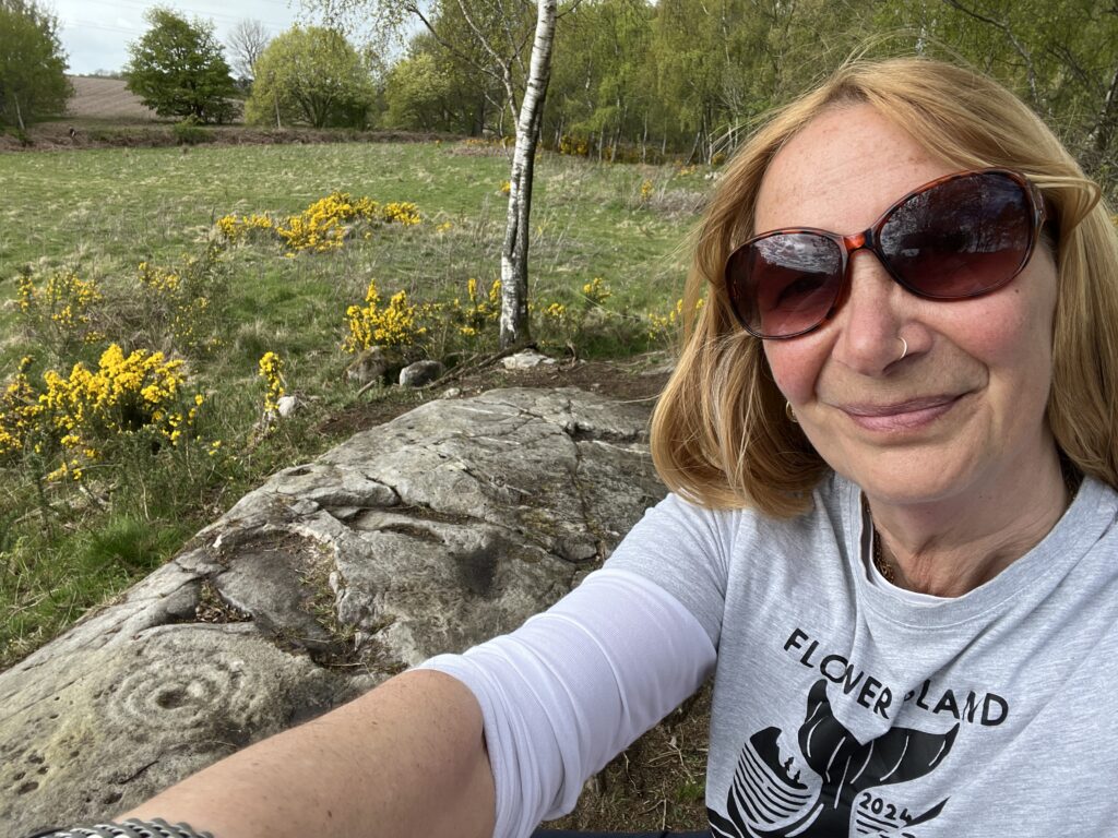 Mandy beside the carved circle marks in stone